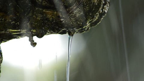 Water drops falling in a ancient rock fountain
