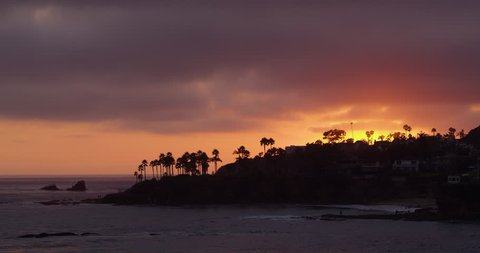 Laguna Beach, California, United States - April, 2017: Contre jour of palm trees on the shore at sunset