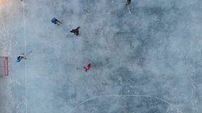 Aerial video of kids playing ice hockey, winter sports outdoor concept. 