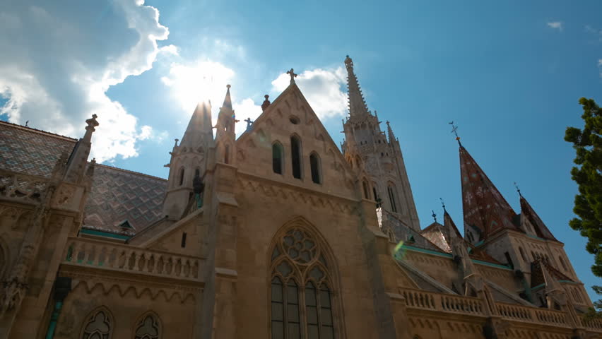 Tilting shot of the Matthias Church, a Roman Catholic church located in Budapest, Hungary, in front of the Fishermans Bastion