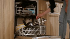 A man puts dirty dishes in the dishwasher 4k