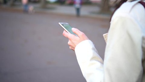 Close up of young woman hands scrolling pictures phone. surfing internet
