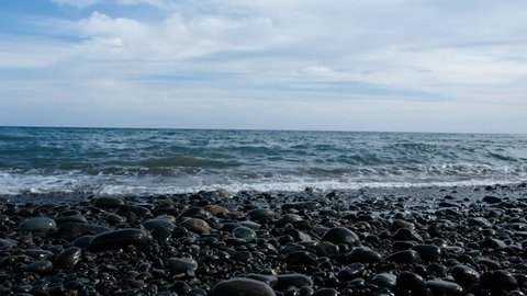 ocean waves on pebble stone beach - stones on sea coast
