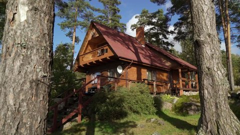 A wooden cottage near lake or sea. Luxury house for vacations. Summer day