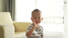 Two to three years old child picks his nose and smile, footage video.