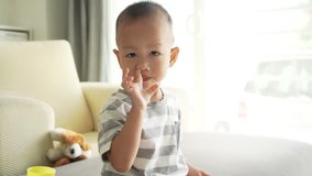 Two to three years old child picks his nose and eats a booger, footage video.