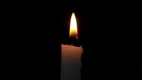 Burning candle on black background 