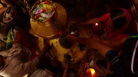 Rishikesh, Uttarakhand / India - July 30, 2018: Indian people worship and put gifts to shivlinga pour water hold plates with prasad top view