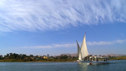 Traditional felucca boats sailing on Nile river near Luxor / Egypt