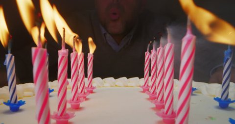 Super slide shot between of a birthday cake and a guy who turns off the them . Concept: macro, holiday, dessert
