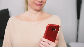 woman flirts talking on video communication from her smartphone. A woman sends a kiss online during a video call using a smartphone.