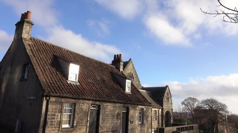 Dunfermline, Scotland, UK; November 18th 2018: Andrew Carnegie birthplace museum. Lovely sun flare forming on a dormer window and wispy white clouds passing overhead in a bright blue sky .