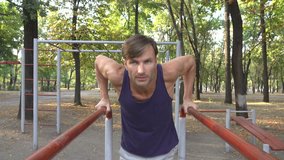 man doing physical exercises in the park. Age forty years. 4k UltraHD footage.