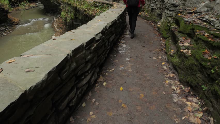 Female tourist walking through Watkins Glen State Park natural gorge 01