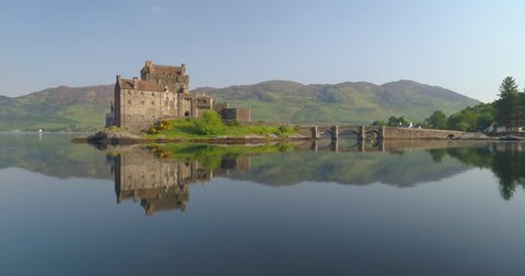 Aerial of Eilean Donan Castle at Sunrise With Still Water