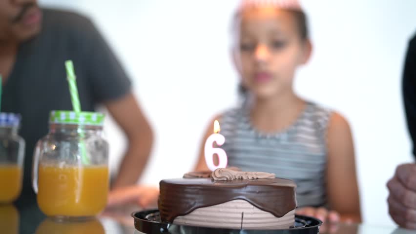 Cute Girl Blowing Candle on Birthday Party