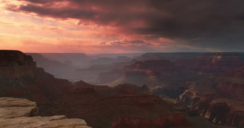 Amazing shot of Grand Canyon vista at sunset with beautiful lighting, clouds, red cliffs and blue skies in 4K DCI.