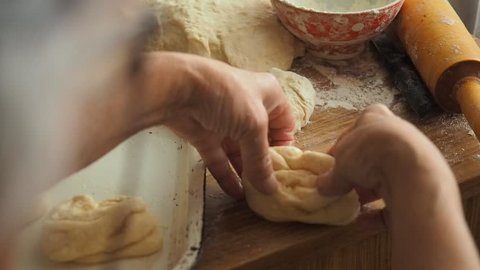 Grandmother cooking, preparing dough in flour, granny hands close up. Senior woman baking pastry in her home kitchen.