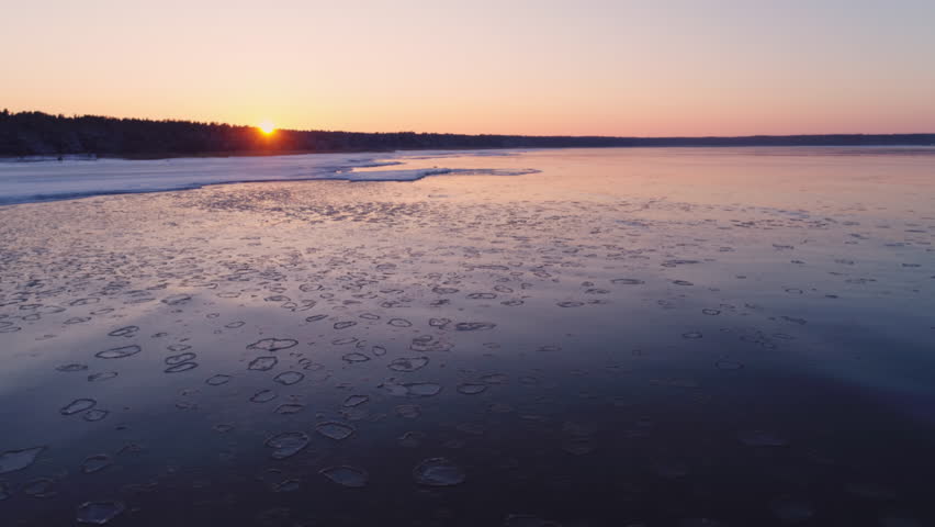Frozen winter sea and ice floes drifting with waves aerial shot