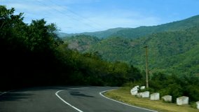 view of highway road between green mountains moving car footage video travel trip landscape in 4k