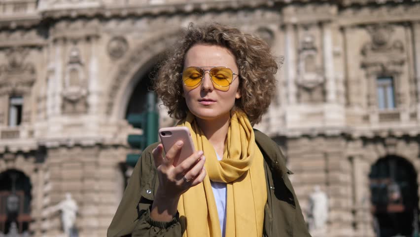Young Woman Calling On The Mobile Phone Walking On Street In City