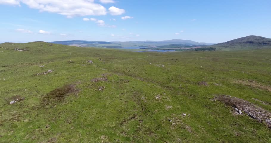 Scottish Low Hilly Landscape Drone Shot with Blue Skies
