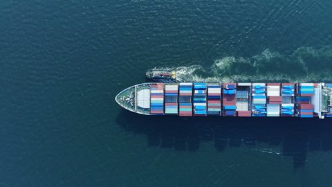 Aerial top view of cargo container ship and trug ship working dragging vessel to yard port concept freight shipping ship.