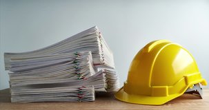 Pile of overload paperwork report of sale and receipt with yellow engineer hat on wood table and white background with copy space time lapse. Business and finance concepts successful footage.