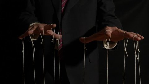 A corporate puppet master manipulating and pulling strings