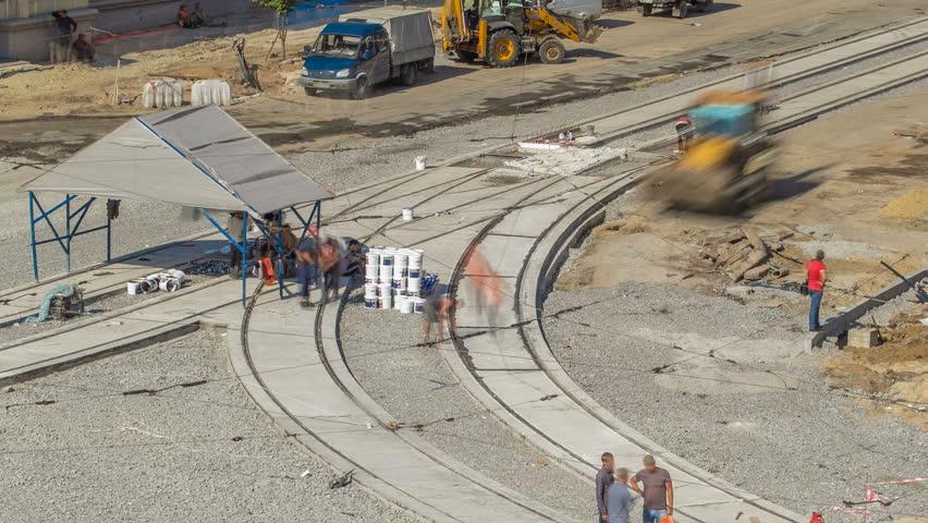 Tram rails at the final stage of their installation and integration into concrete plates on the road night timelapse. Filling by liquid resin for reduction of vibration and noice. The process of