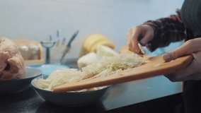 woman in the kitchen preparing a meal concept. girl in the kitchen cuts lifestyle cabbage with a knife. cook vegetarian food healthy food. girl at home in the kitchen slow motion video