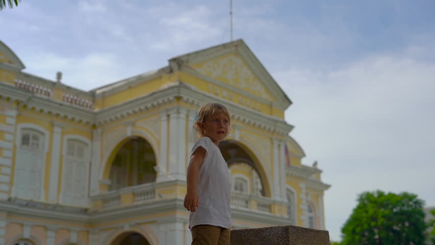 Slowmotion shot of a Little boy playing in front of the City Hall in Georgiatown on Penang island