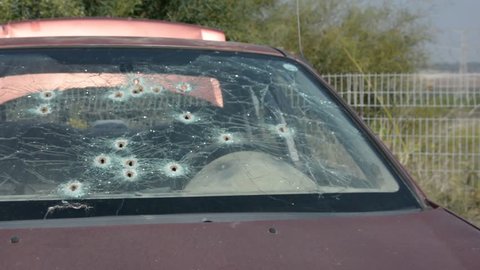 Bullet holes on a car windshield. Terrorist attack. Criminal war.
