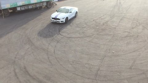 Yerevan, Armenia - 01 May 2017.
Pearl white Ford Mustang GT making donuts with massive smoke and crazy V8 engine sound.