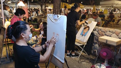 Hua Hin Thailand on November 04, 2018: a man was painting face of person on t-shirt