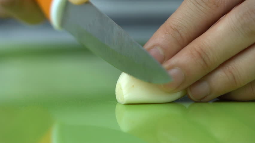 Slow motion shot of cutting Garlic Pieces