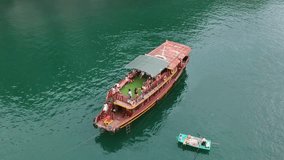People jump into the water from a boat in Ha long bay vietnam. Drone video.