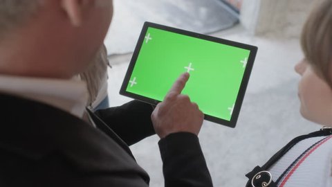 Sales agent holding ipad in new building. Man working as realtor in construction site with digital tablet monitor. Real estate broker showing green screen for internet website