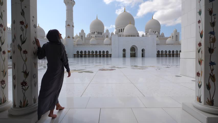 Woman with traditional dress inside Sheikh Zayed Mosque. Abu Dhabi, United Arab Emirates. Royalty-Free Stock Footage #1020006535