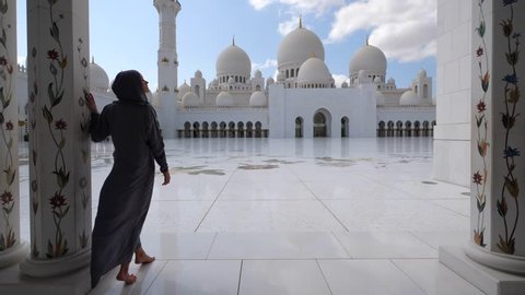 Woman with traditional dress inside Sheikh Zayed Mosque. Abu Dhabi, United Arab Emirates.