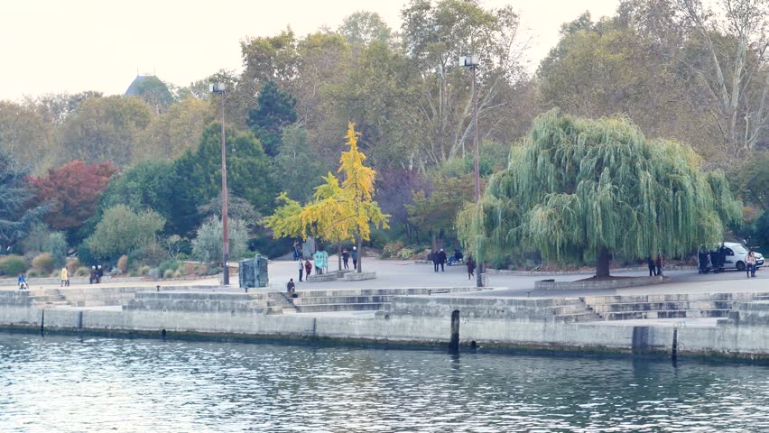 View on the quays in Paris (Seine river) in the jussieu disctrict. People are walking around. Autumn trees. Filmed in november.