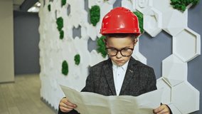 Young boy wearing suit while looking over plans