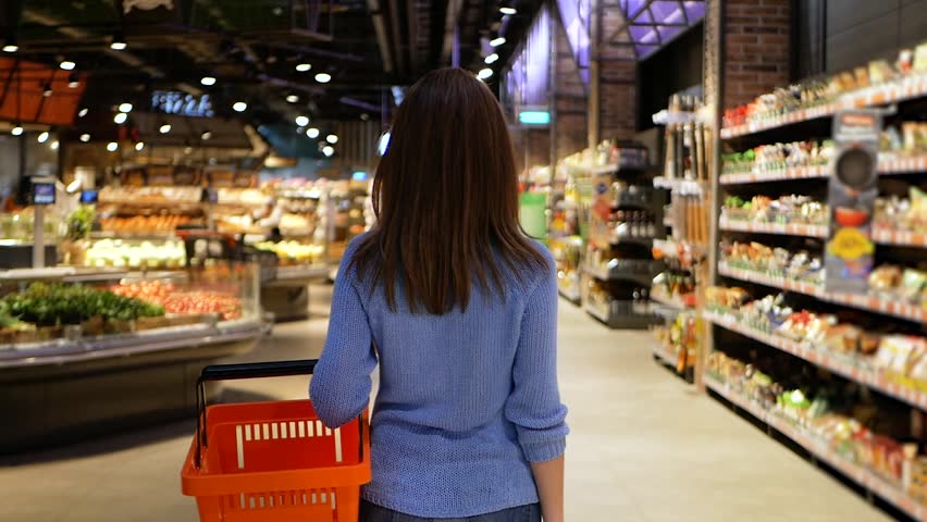 shopping, technology, sale, consumerism and people concept - woman with smartphone and food basket at supermarket or store Royalty-Free Stock Footage #1020014953
