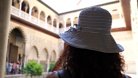 GRANADA, SPAIN - JUNE, 2018: Young woman taking picture inside Alhambra Palace, UNESCO site in Granada, Andalucia.