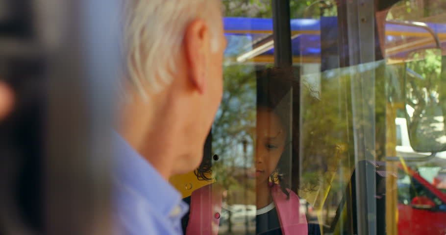 Side view of African american girl commuter taking ticket from driver in bus 