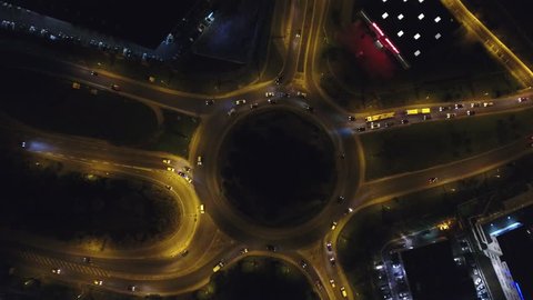 Night overhead view of a roundabout with traffic vehicle. Aerial drone shot