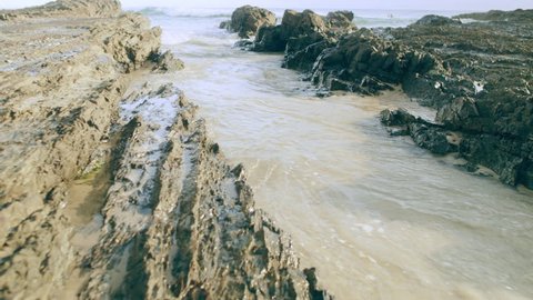 Ocean waves crashing on rocks and coral in Australia. Wide shot on 4k RED camera.