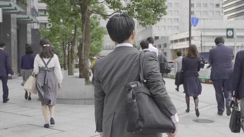 Tokyo, Japan - September 25, 2018: Men in business suits crossing the street in Tokyo,Japan