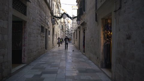 Dubrovnik, Croatia - November 23, 2018: Handheld tracking shot a narrow alleyway in old city
