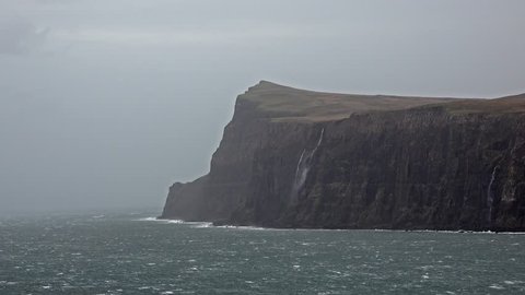 Waterfall on the left stopped and reversed by autumn storm Callum on the cliffs seen from Lower Milovaig - Isle of Skye, Scotland.